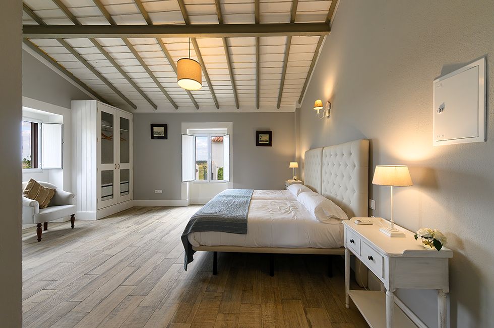 Quarto 6 — cama de casal com roupa de cama bicolor e chão em madeira, Herdade da Boavista