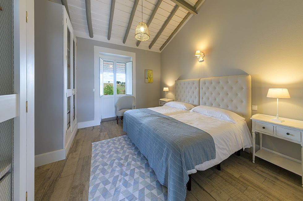 Quarto 9 — cama de casal com cabeceira estofada e teto em vigas, Herdade da Boavista