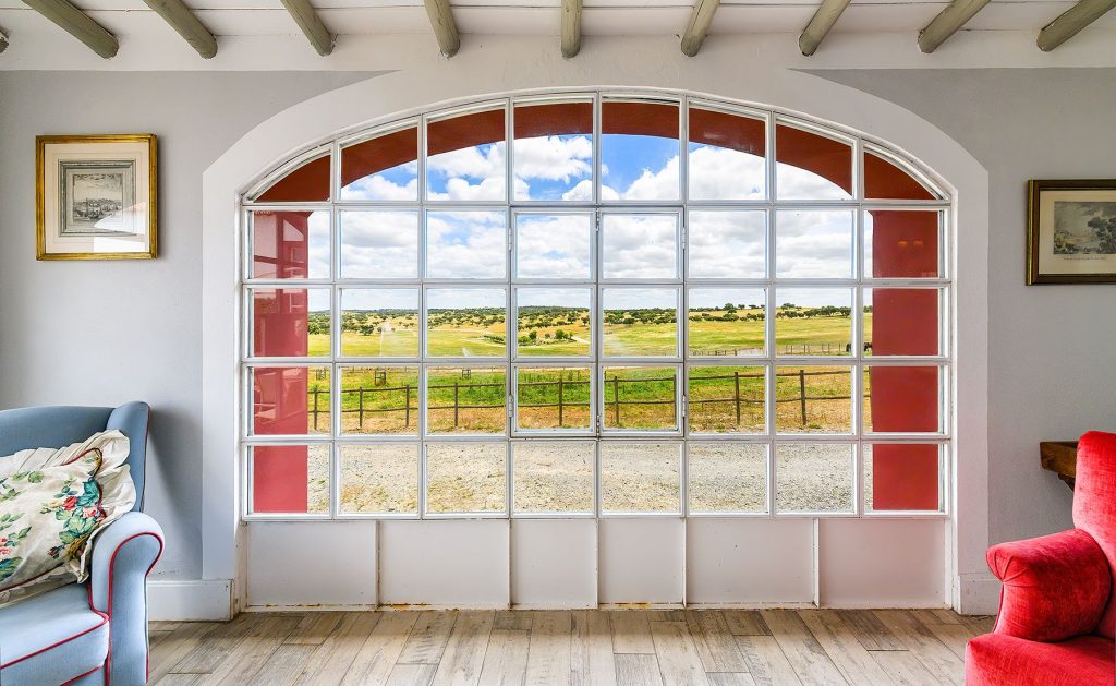 Janela em arco com vista para o campo: Sala de estar com janela em arco e vista para os pastos, Herdade da Boavista